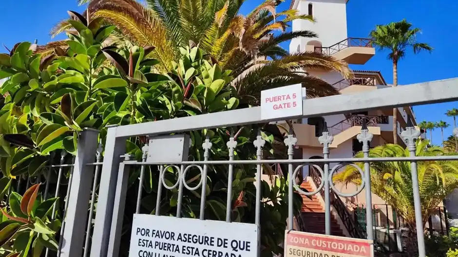 Gated entrance of private property with security signs.