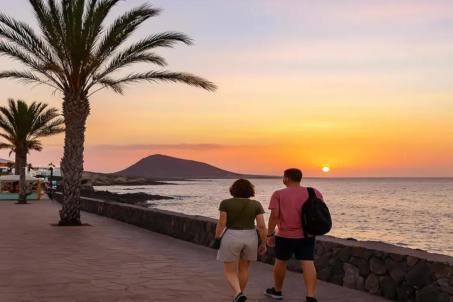 Couple walking along Los Abrigos promenade at sunset, southern Tenerife