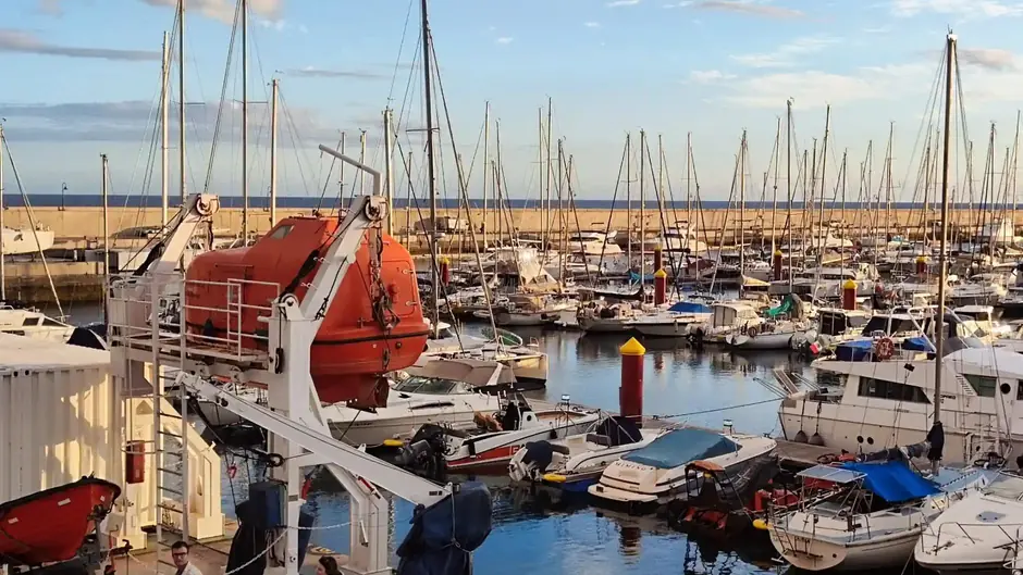 Marina with boats and lifeboat in harbor setting.