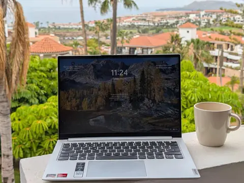 Praca zdalna w Park Albatros, Golf del Sur, Teneryfa — laptop i kawa na balkonie z widokiem na kompleks i ocean.