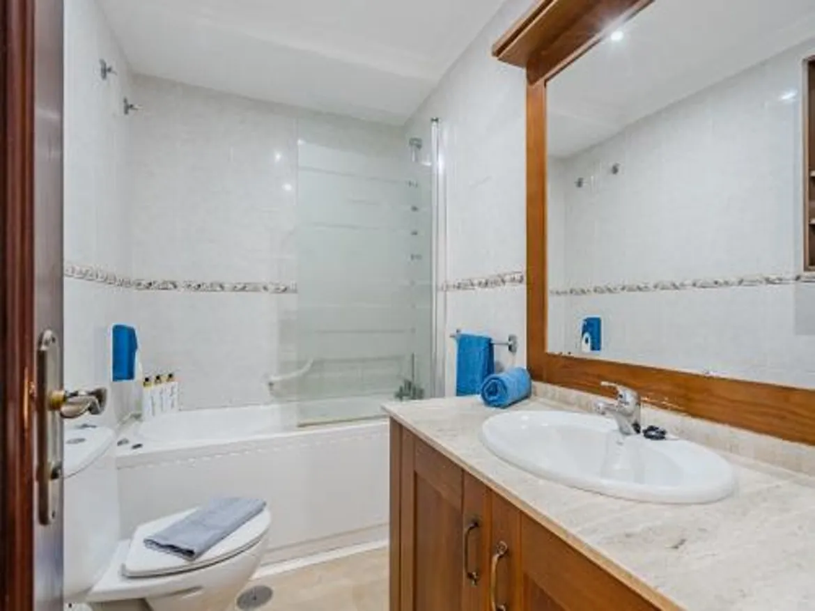 Modern bathroom with sink, mirror, and bathtub.