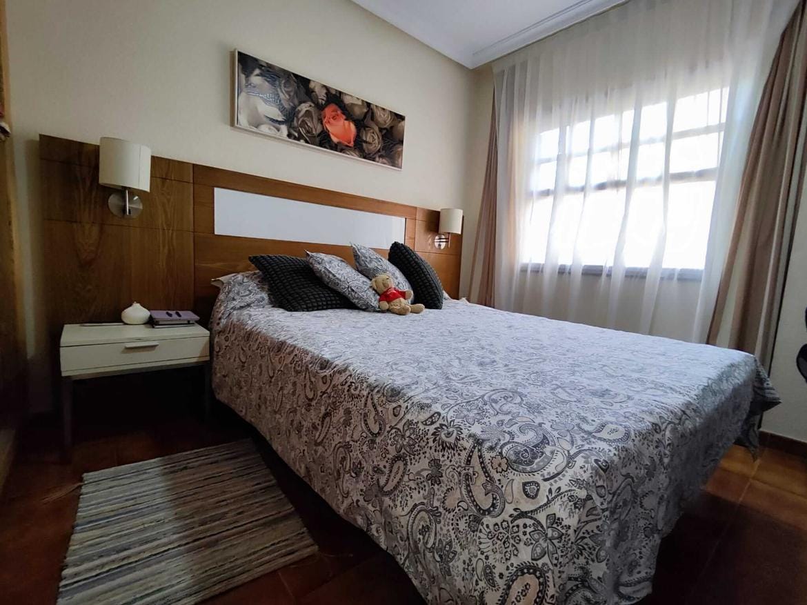 park-albatros-listing-05 Cozy bedroom with bed, pillows, artwork, and window.