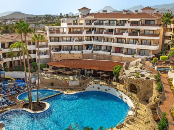 Hotel with pool and mountain view.