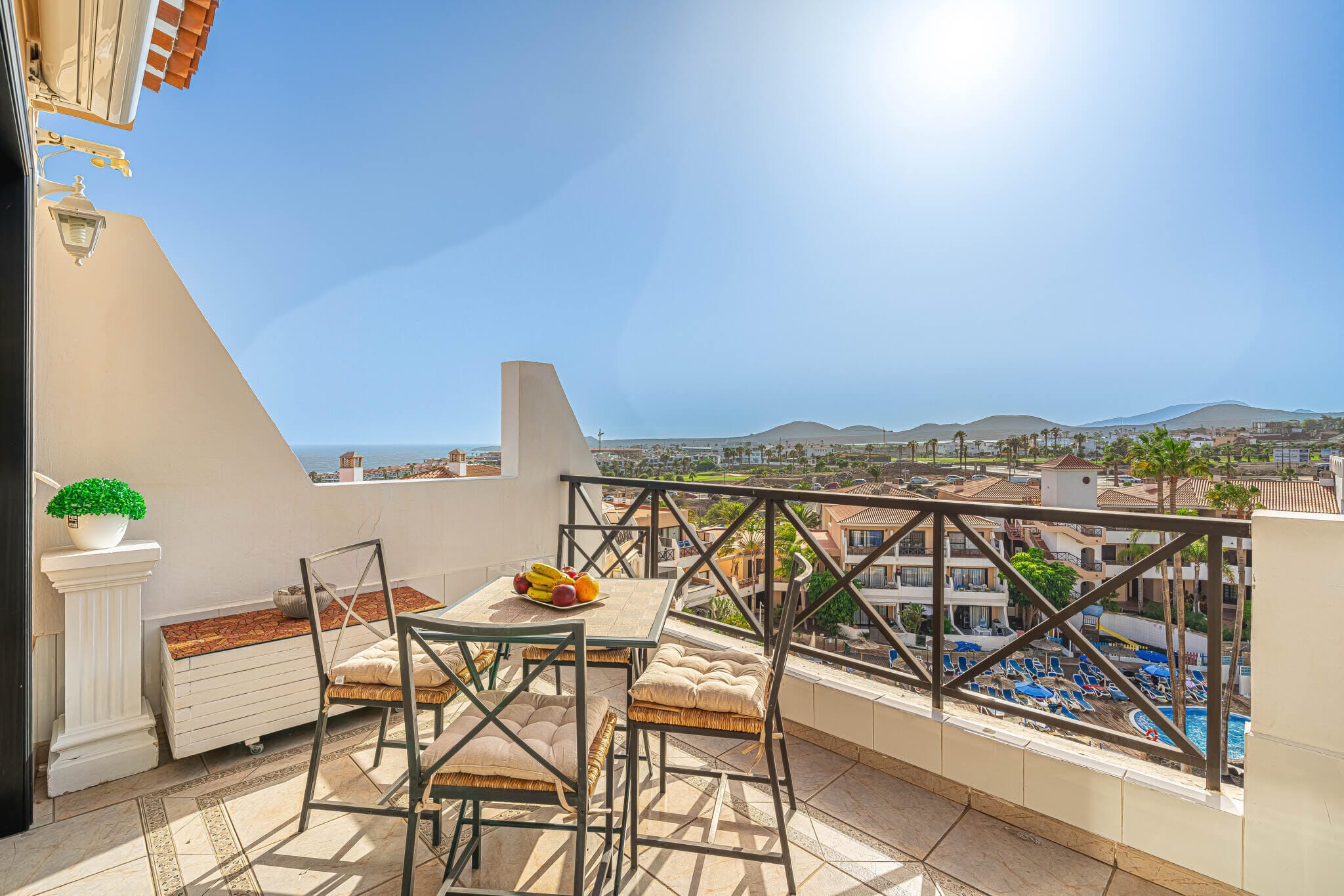 31 Sunlit balcony with ocean view and dining set.
