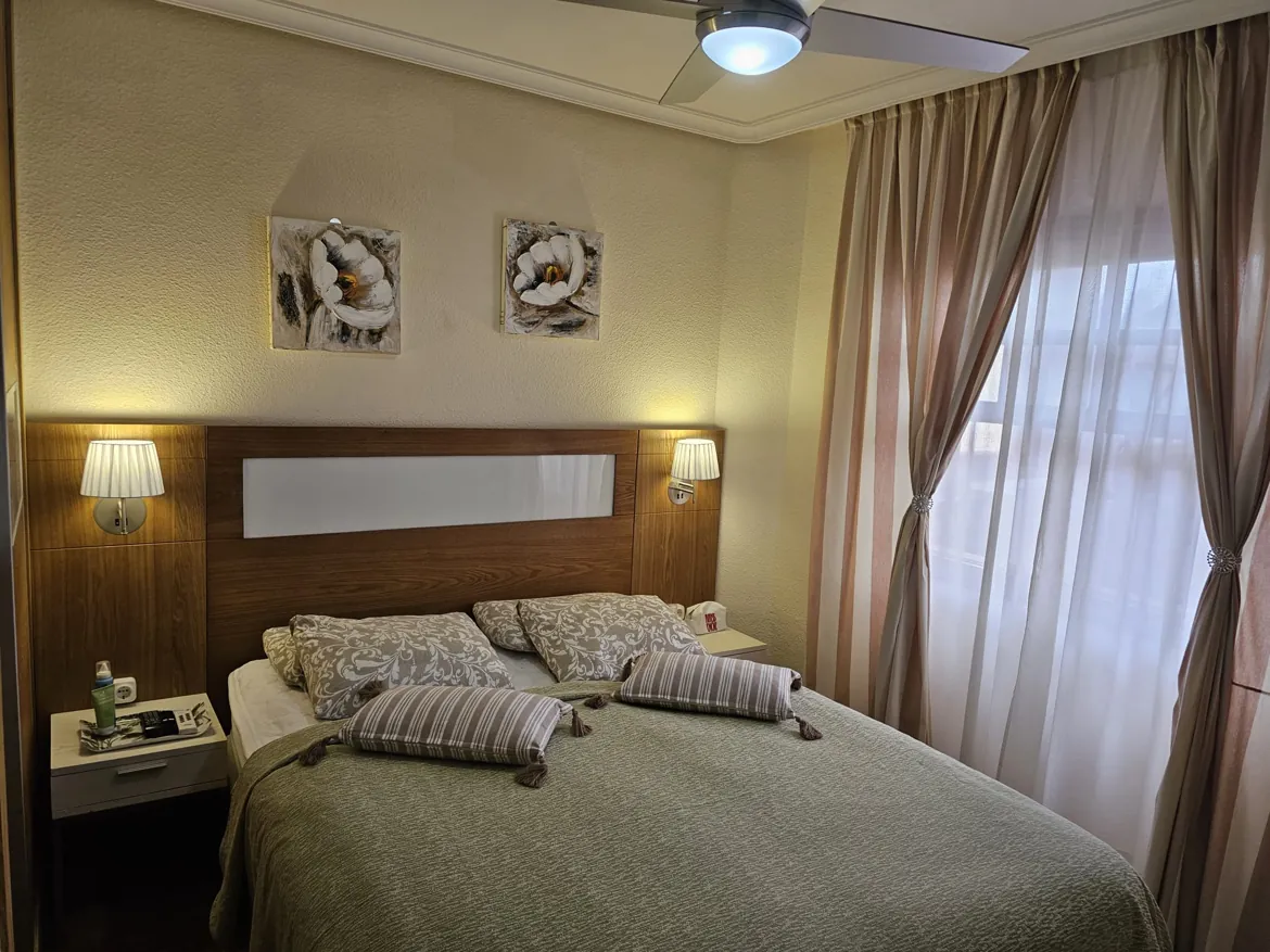 Cozy bedroom with bed, lamps, and curtains