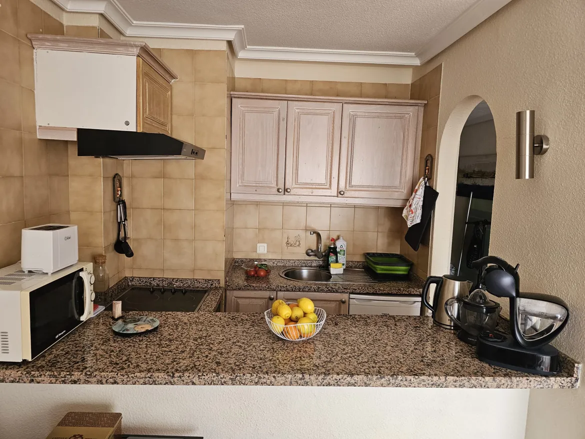 Compact kitchen with granite countertops and appliances.