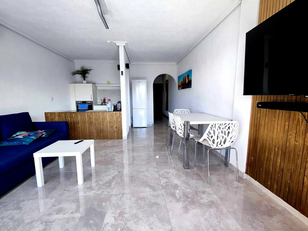 Modern living room with kitchen and dining area.