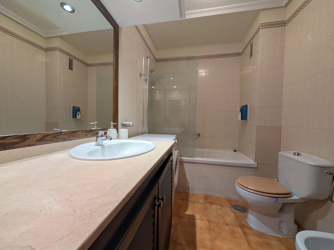 Modern bathroom with sink, toilet, and bathtub.