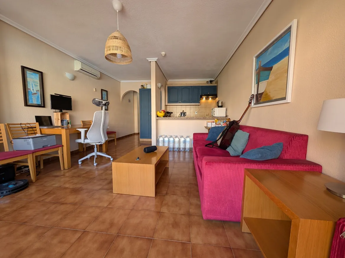 Modern apartment interior with desk and kitchen area.