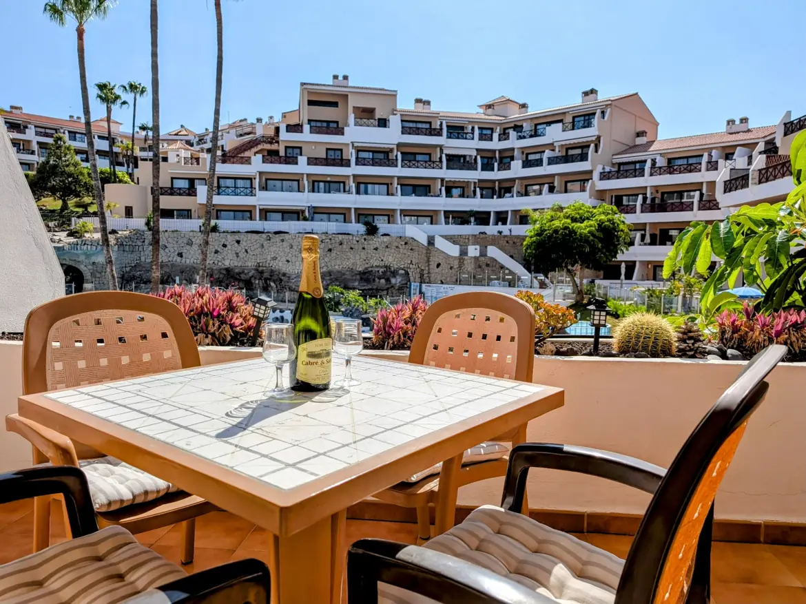 Terrace with wine, overlooking resort and pool.