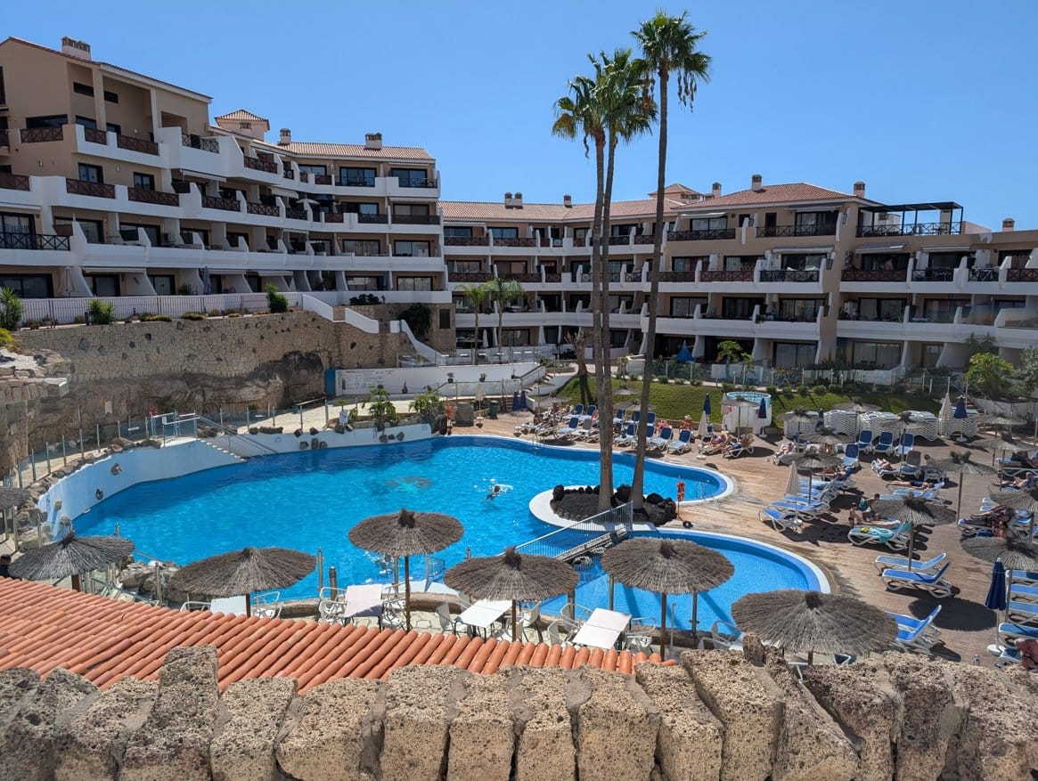 Luxury resort with pool and sunbathing areas.