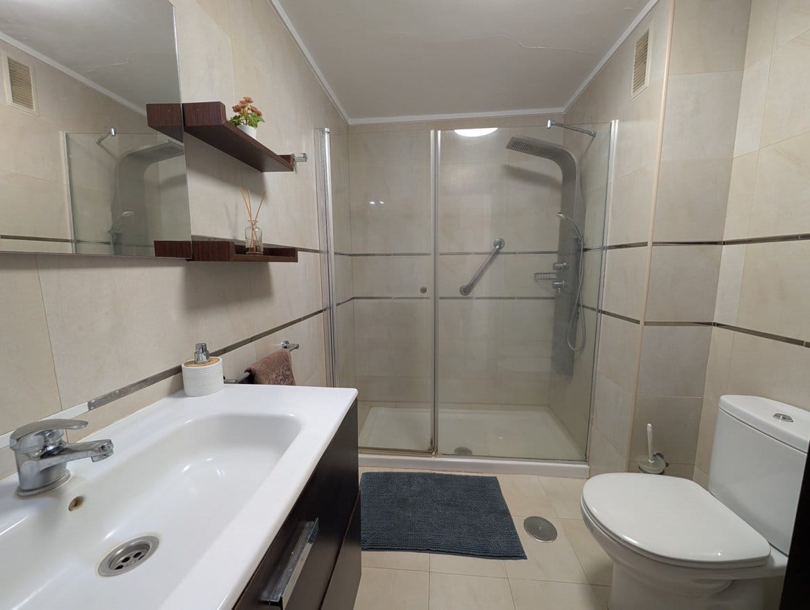 baño 1 optimized Modern bathroom with shower, sink, and toilet.