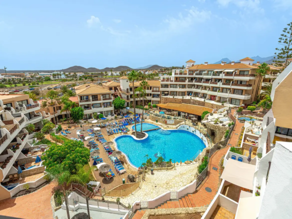 A view of the Parque Albatros resort in Tenerife, featuring the central swimming pool and apartments, where the owners' community (comunidad) is deciding the future of individual rentals (Viviendas Vacacionales, VV).